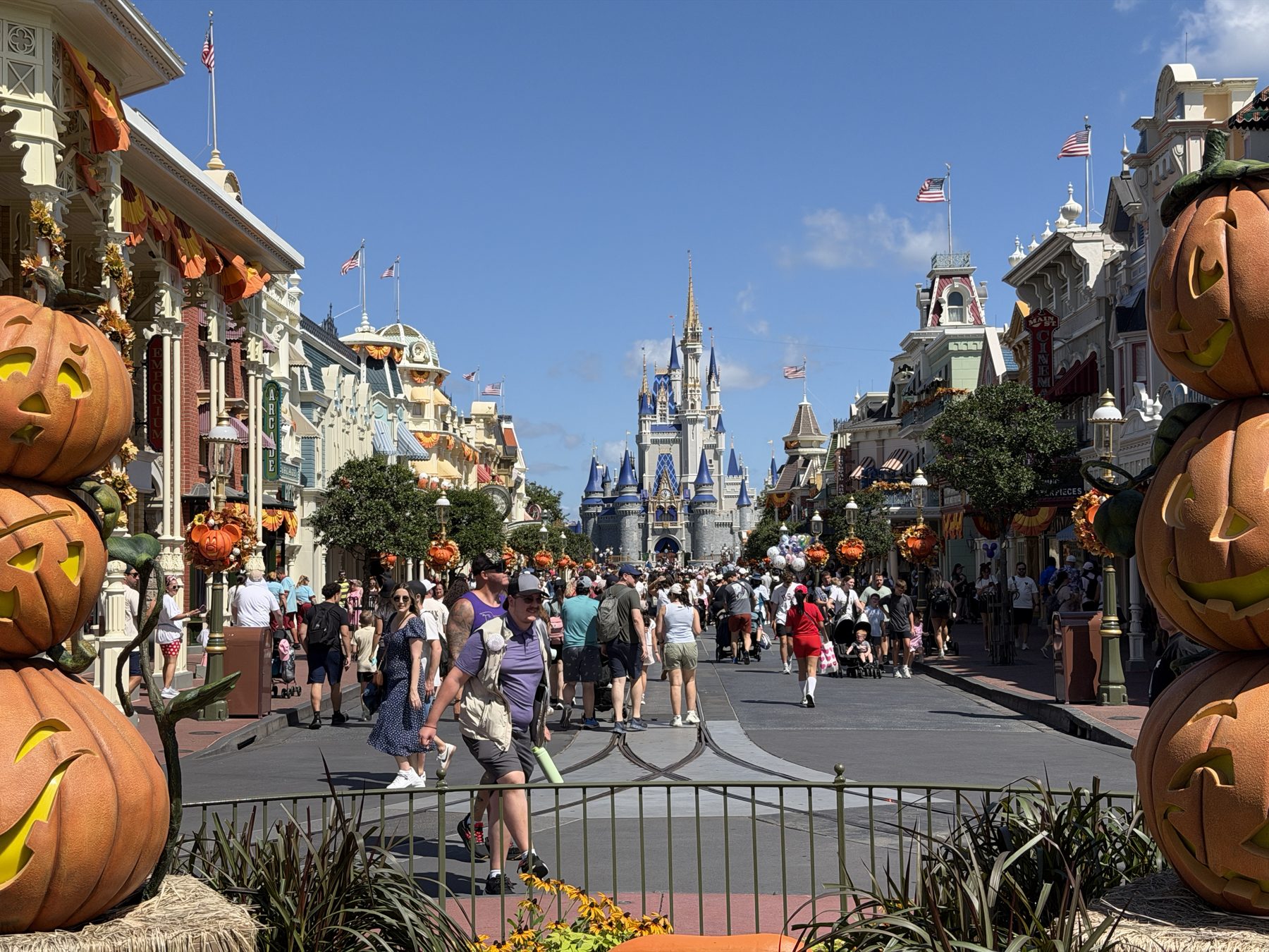 Main Street, U.S.A. at Magic Kingdom decorated with jack-o'-lantern pumpkins for Halloween, with Cinderella Castle at the end of the street.