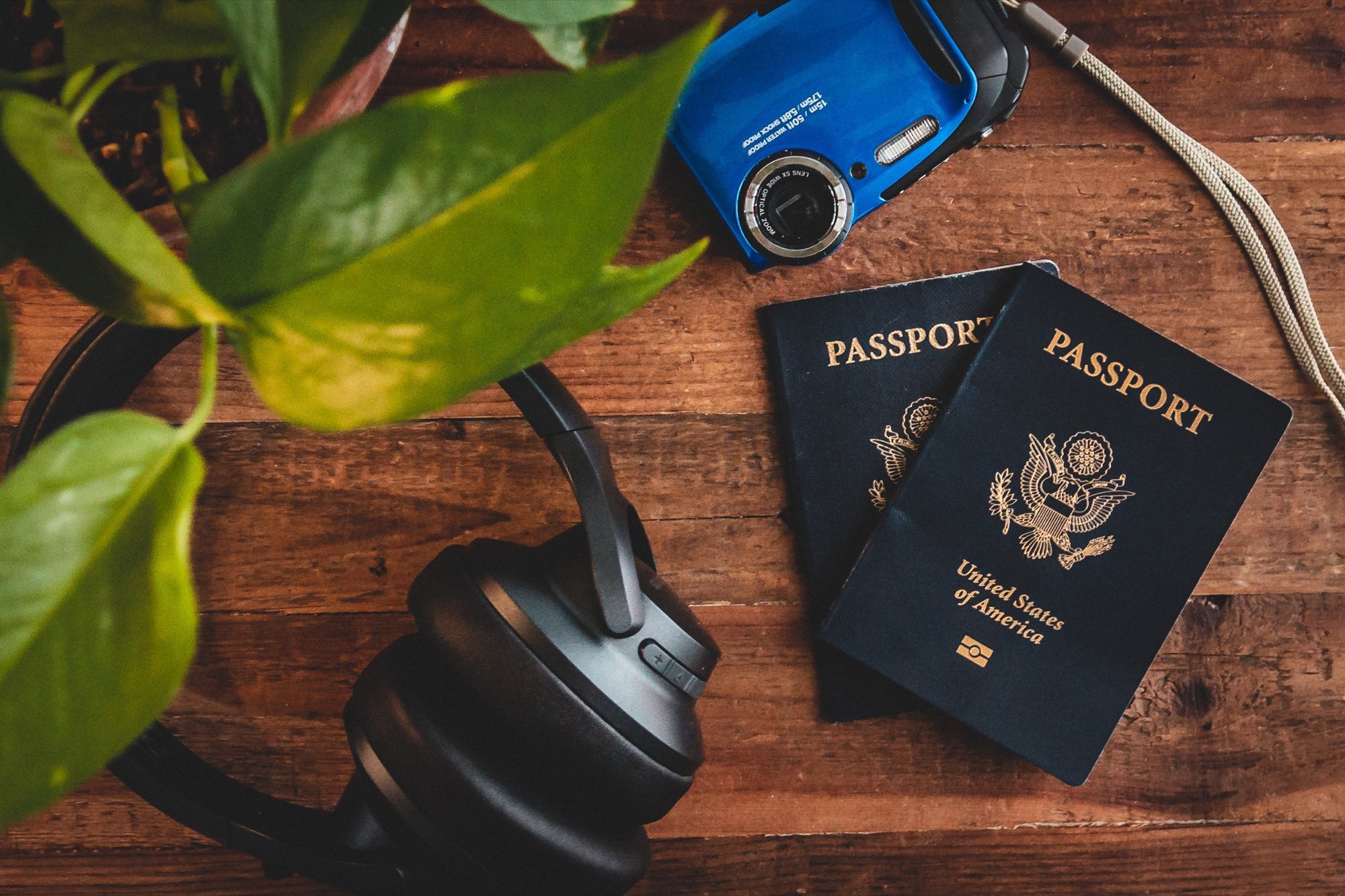 A flat lay of passports, a camera, sunglasses and travel notes on a table.